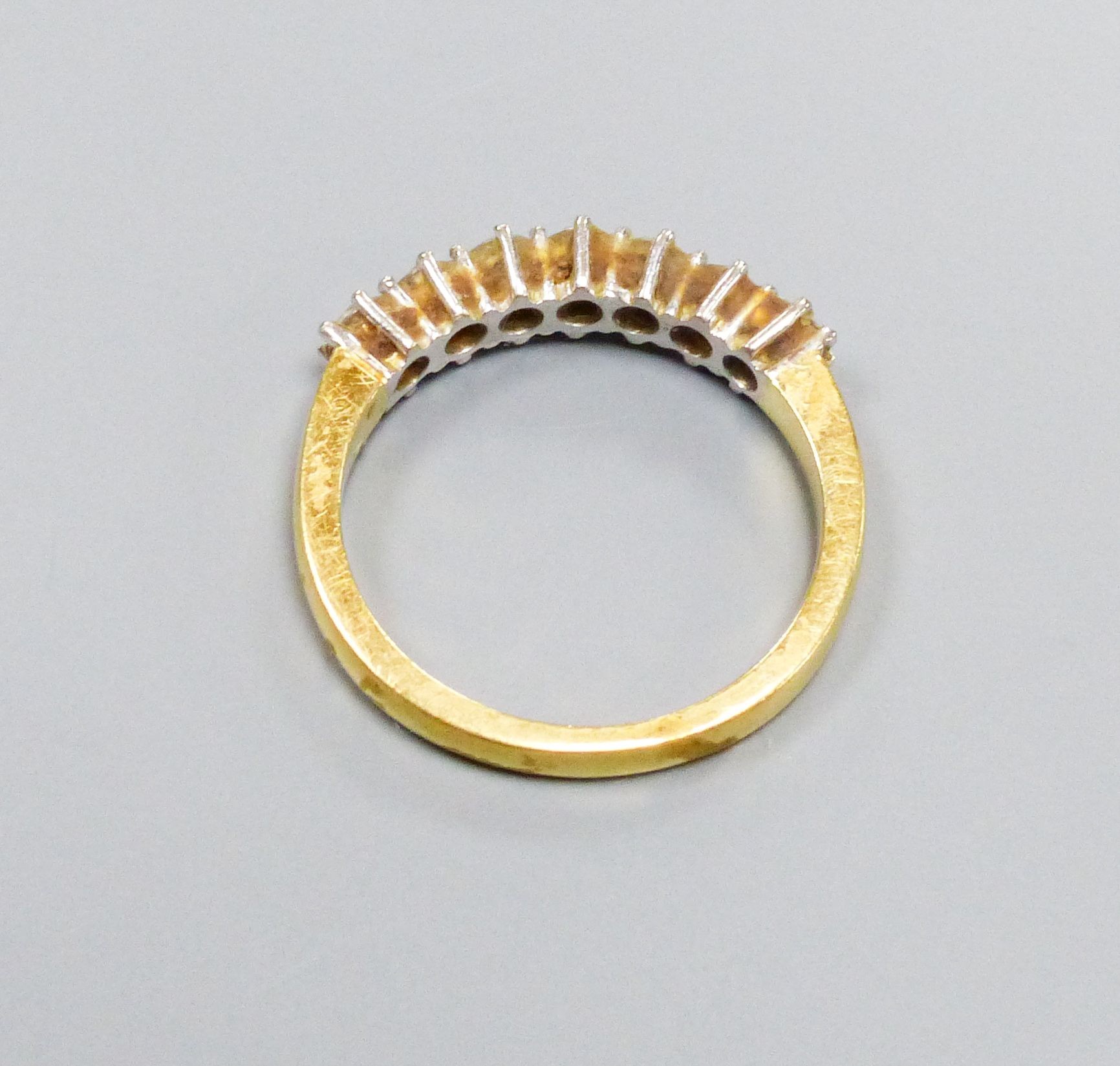 A modern 18ct gold and seven stone diamond set half hoop ring, size P/Q, gross weight 4.4 grams.